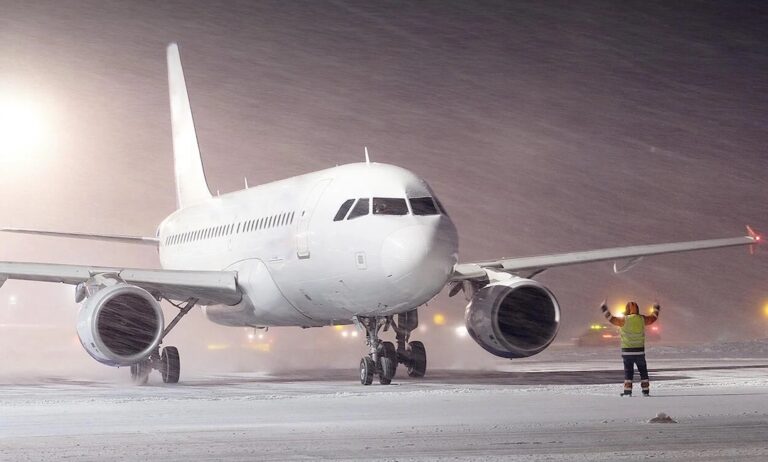 Commercial aircraft navigating the airfield during a snowstorm